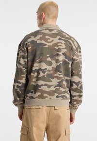 Camo bomberjack in beige, groen en bruin, met een relaxte pasvorm, geribde manchetten en een ronde hals.