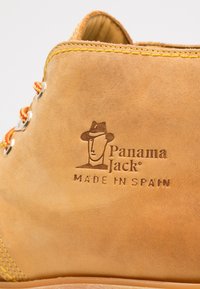 Kanna nahkasaapad, millel on sile tekstuur, kollane õmblus ja metallist silmad. Küljele on pressitud logo "Panama Jack Made in Spain."
