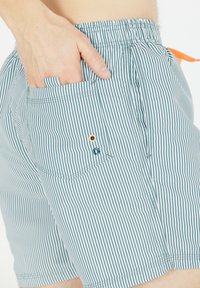 Badehosen für Herren mit einem hellblauen und weißen Streifenmuster, elastischem Bund, Seitentasche und kontrastierendem orangefarbenem Kordelzug.