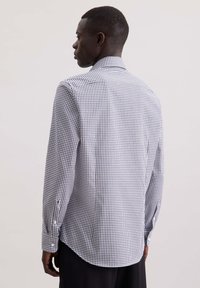 Geruit shirt in zwart en wit, met lange mouwen, knoopmanchetten en een taps toelopende pasvorm. Gladde stof met een zachte textuur en een gebogen zoom.