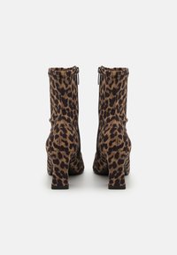 Stivaletti alla caviglia con stampa leopardata, realizzati in un tessuto texturizzato, con tacco quadrato e zip laterali. Il design presenta una vestibilità aderente e un motivo audace.