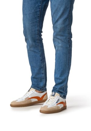 Scarpe da ginnastica bianche e arancioni con accenti color sabbia, materiali in pelle e mesh, design a profilo basso e suola in gomma testurizzata.