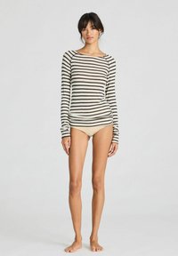 Valkoinen ja tummanruskea raidallinen pitkähihainen paita, jossa on venepääntie ja slim fit -määrä, yhdistettynä beigeisiin bikinitossuihin.