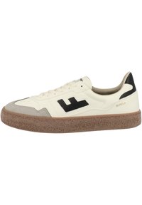 Valkoinen nahkakengät mustilla yksityiskohdilla, harmaa mokkanahkainen kärki ja teksturoitu ruskea kumipohja. Ominaisuuksiin kuuluu klassinen nauhakiristysdesign ja brändäys.