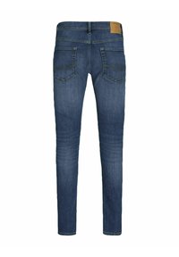 Jeans skinny de denim azul con un talle medio, que presentan un parche de cuero marrón, bolsillos traseros con detalles de costura y un corte clásico.