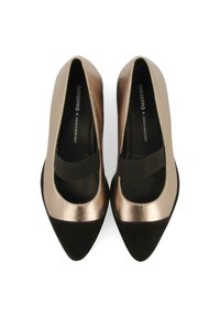 Parte superior de bronce metálico con punta de ante negro, silueta redondeada y correa elástica en el empeine. Suave forro interior para mayor comodidad.