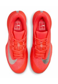 Rode sportieve sneakers gemaakt van lichtgewicht mesh en synthetisch materiaal, met een opvallende zilveren Nike swoosh en gestructureerde zolen.