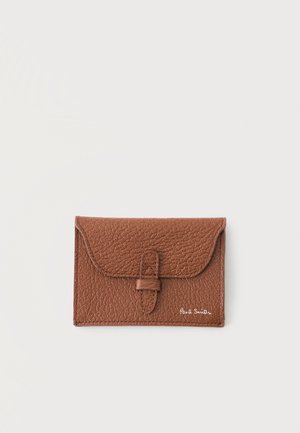 Porte-cartes en cuir marron texturé avec rabat et fermeture par boucle, avec le logo blanc Paul Smith en bas à droite.