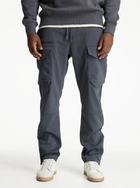 Grå cargobyxor i slät väv, med flera sidofickor, elastisk midja och tapered ben. Bärs med vita sneakers.