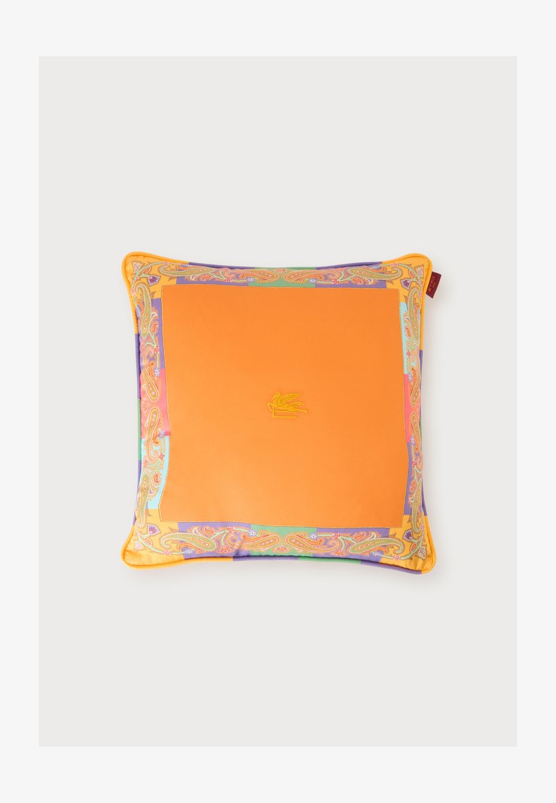 Coussin carré avec un centre orange vif et une bordure à motif cachemire multicolore sur un fond uni.