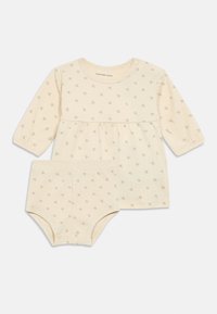 Conjunto de bebé em bege claro, com uma blusa de mangas longas com cintura franzida e calções a condizer, decorado com pequenos padrões do logo CK.