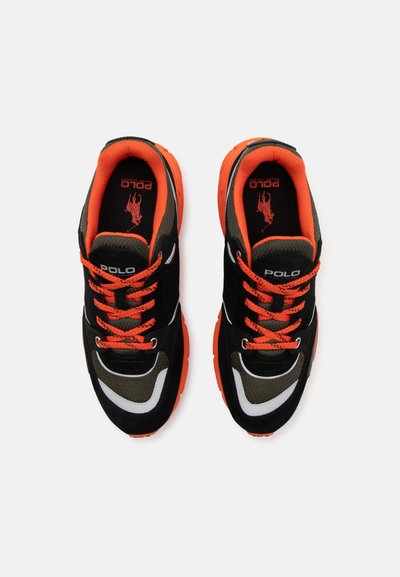 Schwarze und orange Sport Schuhe aus Mesh- und Wildledermaterialien, mit leuchtend orangen Schnürsenkeln, markiertem Logo und kontrastierenden weißen Akzenten.