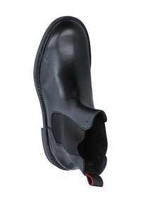 Stivale alla caviglia in pelle nera con lati elasticizzati, punta rotonda e suola testurizzata. Presenta una linguetta rossa per una facile calzata. Finitura liscia.