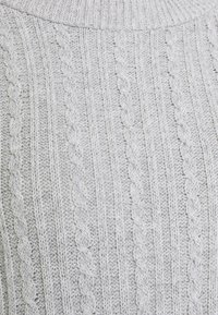 Helle graue Strickpullover mit einem strukturierten Muster aus erhabenen Kabeln und vertikalen Rippen. Verfügt über einen hohen Kragen und eine weiche, kuschelige Textur.