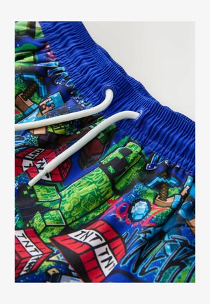 Maudymosi šortai su ryškiai mėlynu pagrindu, margi su „Minecraft“ tema, su elastine juosmens juosta ir baltais raišteliais.