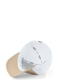 White mesh baseball cap with a gold glitter brim. Interior features branded labels and a soft lining for comfort.