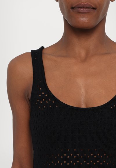 Top fără mâneci tricotat, de culoare neagră, cu decolteu rotund, model cu țesătură deschisă și textură, punând accent pe respirabilitate și design casual.