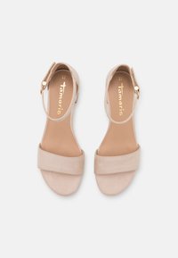 Beige avointoppaiset sandaalit, joissa on leveä etuhihna ja säädettävä nilkkahihna. Pehmeä mokkanahkatunne ja minimalistinen muotoilu. Koko 37.