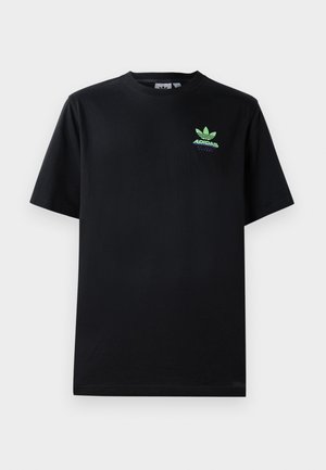 T-shirt en coton noir avec des manches courtes, un col rond et un logo Adidas vert avec un design de feuille sur la poitrine gauche.