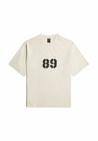 Crème-kleurig katoenen t-shirt met korte mouwen en een ronde hals, met een versleten zwarte afdruk van het nummer "89" op de voorkant.