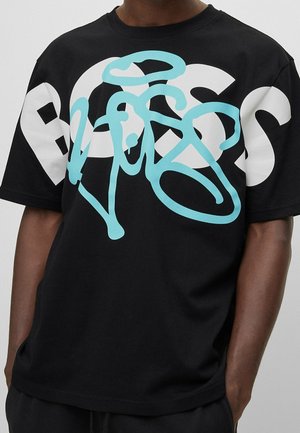 Schwarzes Baumwoll-T-Shirt mit großen weißen und hellblauen grafischen Text. Das Shirt hat einen lockeren Schnitt und einen Rundhalsausschnitt.