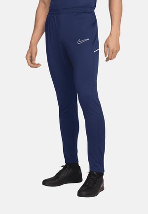 Marine blauwe sportbroeken van gestructureerde stof met een slim fit, voorzien van een wit Nike-logo en een zijzak met rits.