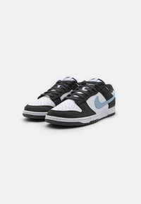 Sneakers in bianco e nero realizzati in pelle e suede, con punta perforata, design con lacci, accenti azzurri e suola in gomma.
