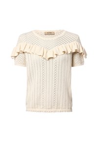 Camiseta de punto crema con un patrón de diamantes texturizado, mangas cortas y un escote con volantes. La tela presenta una textura suave y ligera.