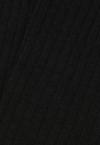 Tejido negro acanalado con una superficie suave y texturizada. El patrón consiste en líneas verticales, creando una apariencia elástica y ajustada.
