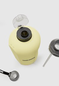 Yellow water bottle with a black lid and a transparent flip-top opening. Features a black straw and a strap for carrying. Text visible: "SMILODOX."