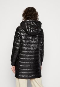 Czarna kurtka puchowa o błyszczącym wykończeniu, z poziomymi przeszyciami i kapturem. Posiada boczne zamki błyskawiczne oraz elastyczne mankiety dla lepszego dopasowania.