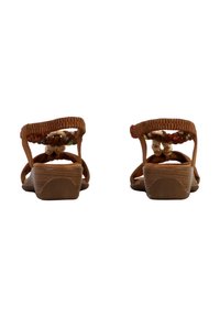 Sandales brunes tressées avec un talon compensé bas, ornées de perles colorées et d'une sangle texturée. Conçues pour un port ouvert à l'arrière.
