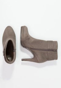 Stivaletti alla caviglia in suede grigio con punta appuntita e tacco a stiletto di 10 cm. Presentano una zip laterale e un pannello texturizzato attorno alla caviglia.