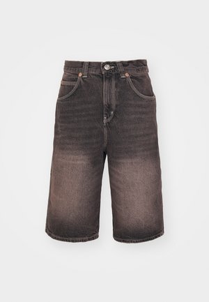 Sötétbarna farmer rövidnadrág, elhalványult gradienst mutatva, öt zsebbel és fémből készült gombzárral. Kontrasztos varrás, valamint nyers szegélyek jellemzik.