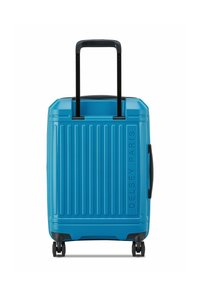 Maleta rígida azul con ranuras verticales, asa retráctil y cuatro ruedas. Presenta un asa lateral y el nombre de la marca en relieve, Delsey Paris.