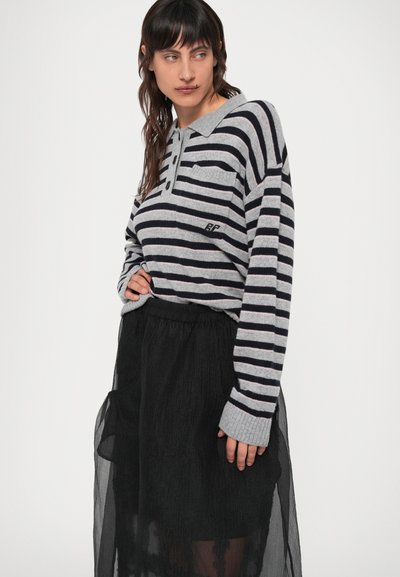 Röstripline pikkade varrukatega sviiter hallide ja mustade horisontaalsete triipudega, varustatud nööpidega ja rinna-taskuga, koos musta läbipaistva seelikuga.