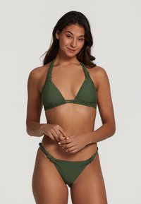 Set bikini verde con top triangolare e legacci al collo e slip minimal con dettagli arricciati ai lati. Tessuto dalla trama liscia, design senza cuciture.