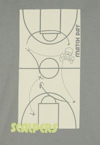 Graues T-Shirt mit einem Basketballfeld-Design in hellem Creme, verziert mit Pfeilen und einem Totenkopf-Symbol. Der Text lautet "MATCH DAY" und "SCALPERS."