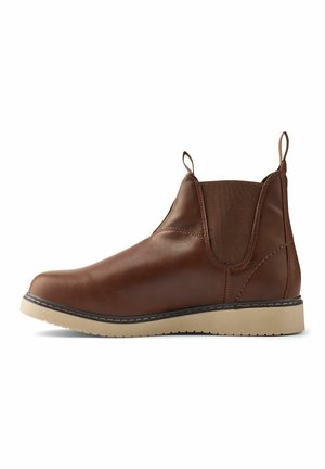 Bottine en cuir brun avec des panneaux latéraux élastiques, des pattes de traction et une semelle en caoutchouc beige. Texture lisse avec des détails de couture contrastants.