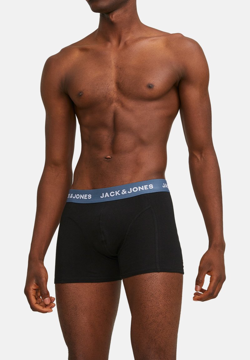 Schwarze Boxershorts mit einem blauen elastischen Bund, der das Logo "JACK & JONES" trägt. Hergestellt aus weichem, dehnbarem Material für optimalen Tragekomfort.