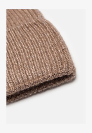 Beżowa czapka dziergana z prążkowaną teksturą, z podwiniętym mankietem i miękkim, gęstym materiałem. Zaokrąglony kształt bez widocznych wzorów czy akcentów.