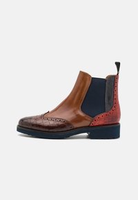 Bottine en cuir marron avec côtés élastiques, bout texturé en motif crocodile, et panneaux d'accent rouge. Dotée d'une semelle en caoutchouc bleue.
