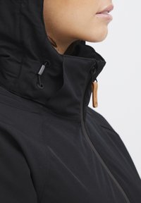 Black waterproof jacket with a high collar, featuring a cinch cord and leather zipper pull. Smooth texture with subtle stitching details.