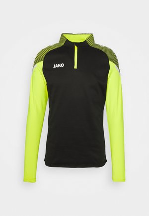Schwarzes langärmliges Sportoberteil mit einem Viertel-Reißverschluss, das leuchtend neon-gelbe Ärmel und gemusterte Schulterakzente mit der Marke "JAKO" aufweist.