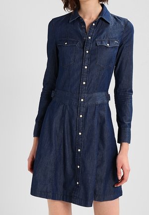 Denim shirt dress in dark blue with long sleeves, button-up front, two chest pockets, and a fitted waist with a flared skirt.
