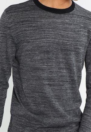 Pull gris à manches longues avec une texture subtile, présentant un col rond côtelé noir. Le tissu a un motif chiné, ajoutant de la profondeur.