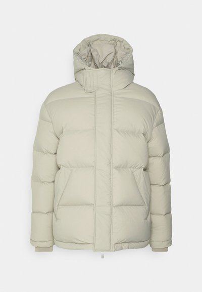 Lys beige pufferjakke med høj krave og hætte, der har quiltede sektioner, forlommer og elastiske ribkanter. Glat stofstruktur.