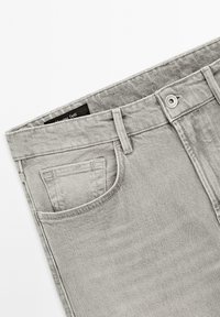 Jeans in denim grigio con taglio dritto, una tasca posteriore singola, chiusura con bottone in metallo e una texture tenue. Etichetta visibile all'interno della vita.