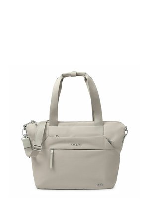 Beige tote bag with dual handles, adjustable shoulder strap, front zip pocket, and subtle brand logos on fabric surface.