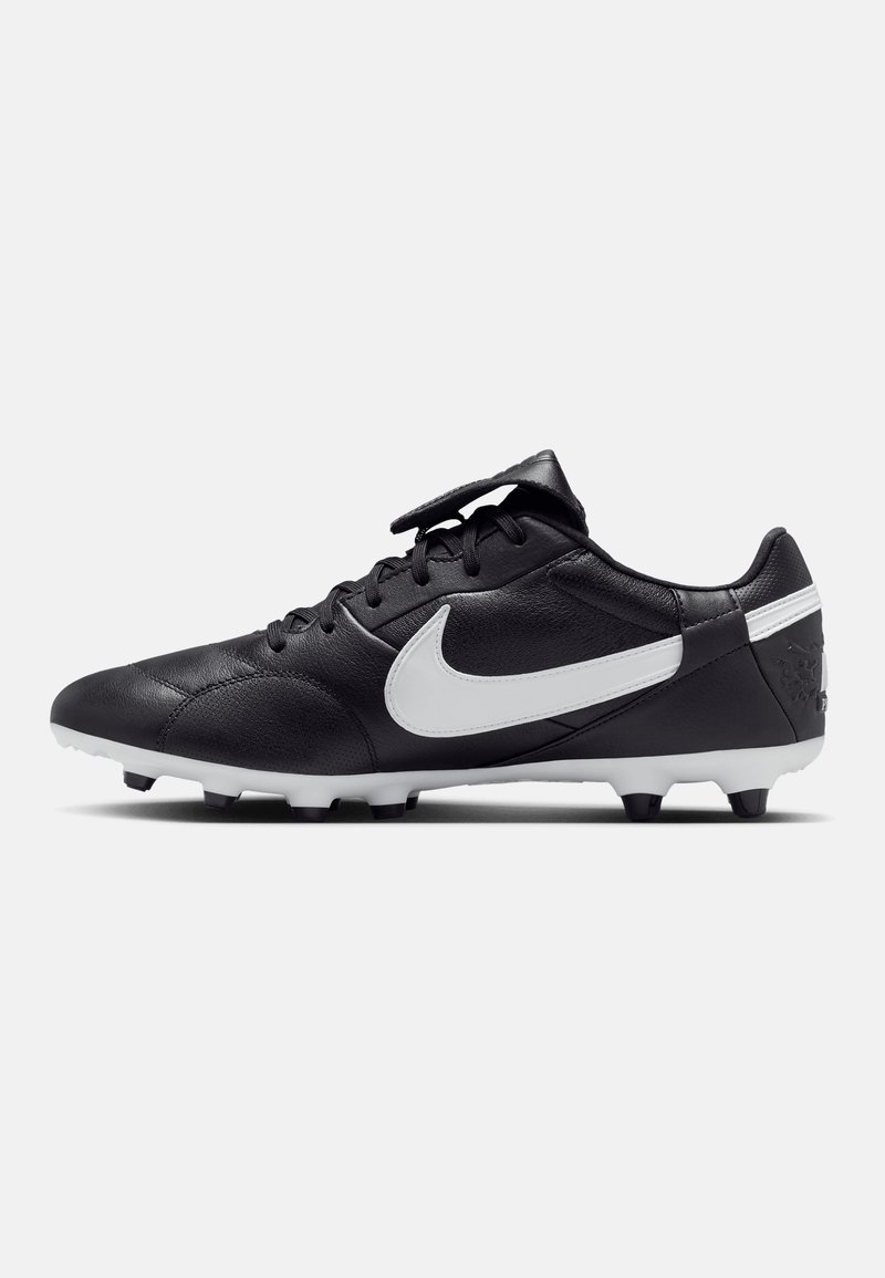 Chaussures de football en cuir noir avec des accents blancs, pointe arrondie, lacets plats et crampons moulés pour une meilleure traction. Logo Nike sur le côté.